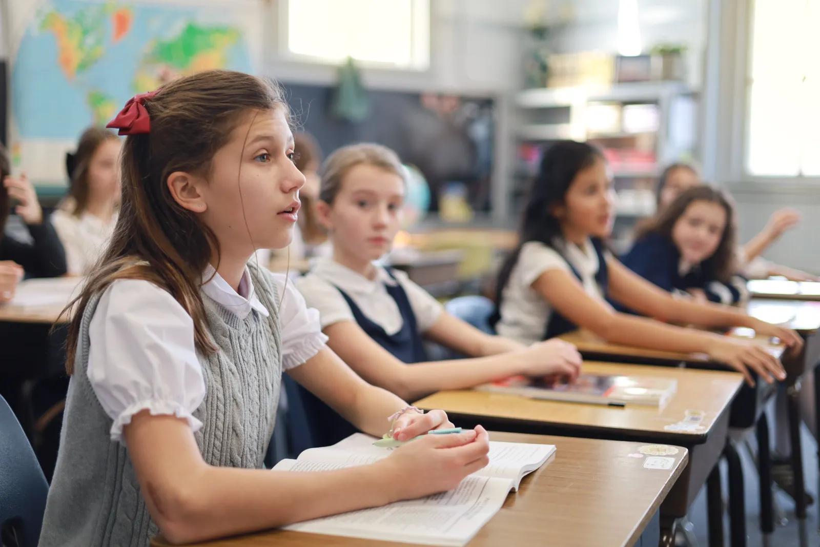 Students in uniform listen closely during a lesson